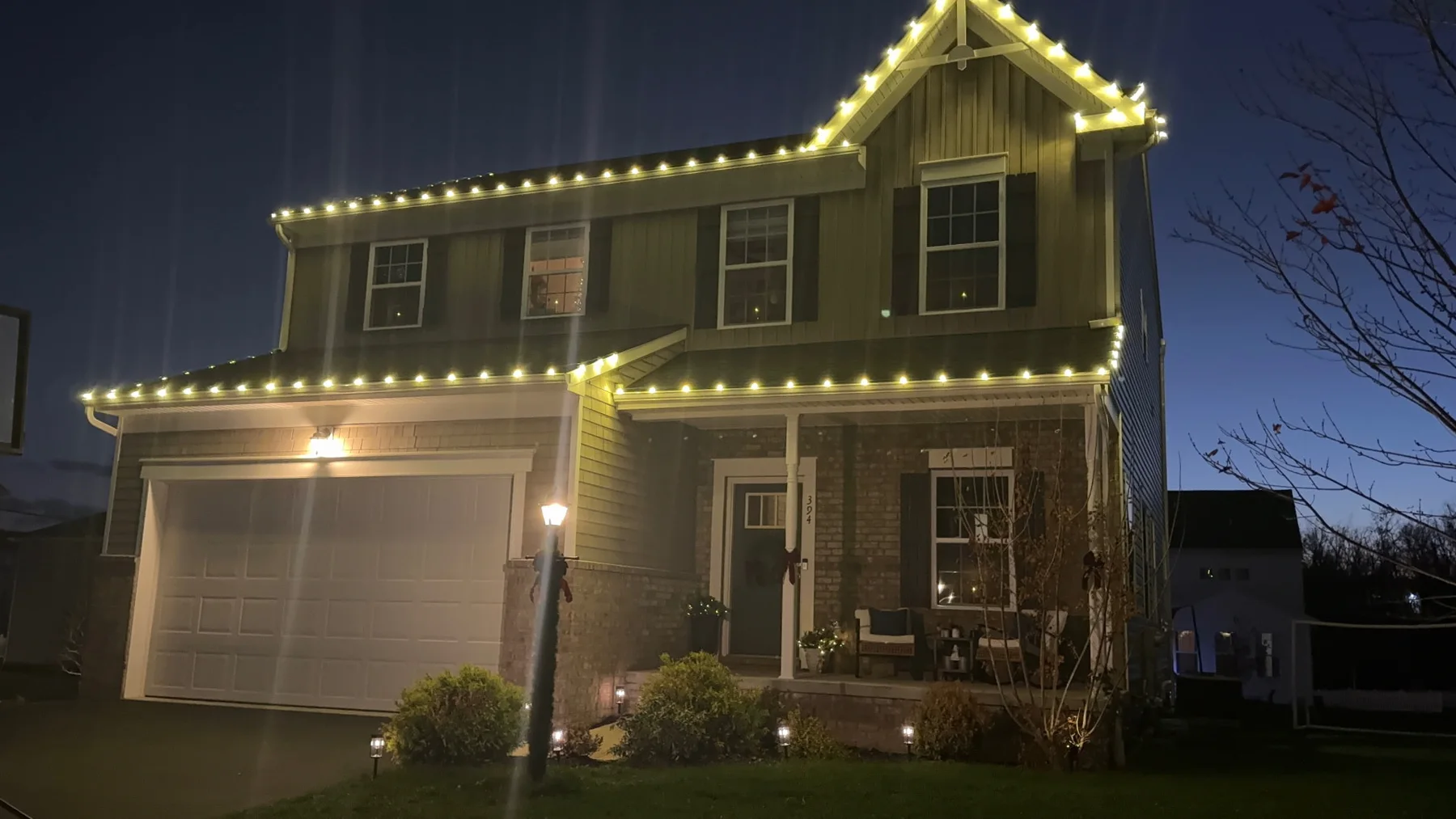 Warm white Christmas roofline lighting on a two-story home