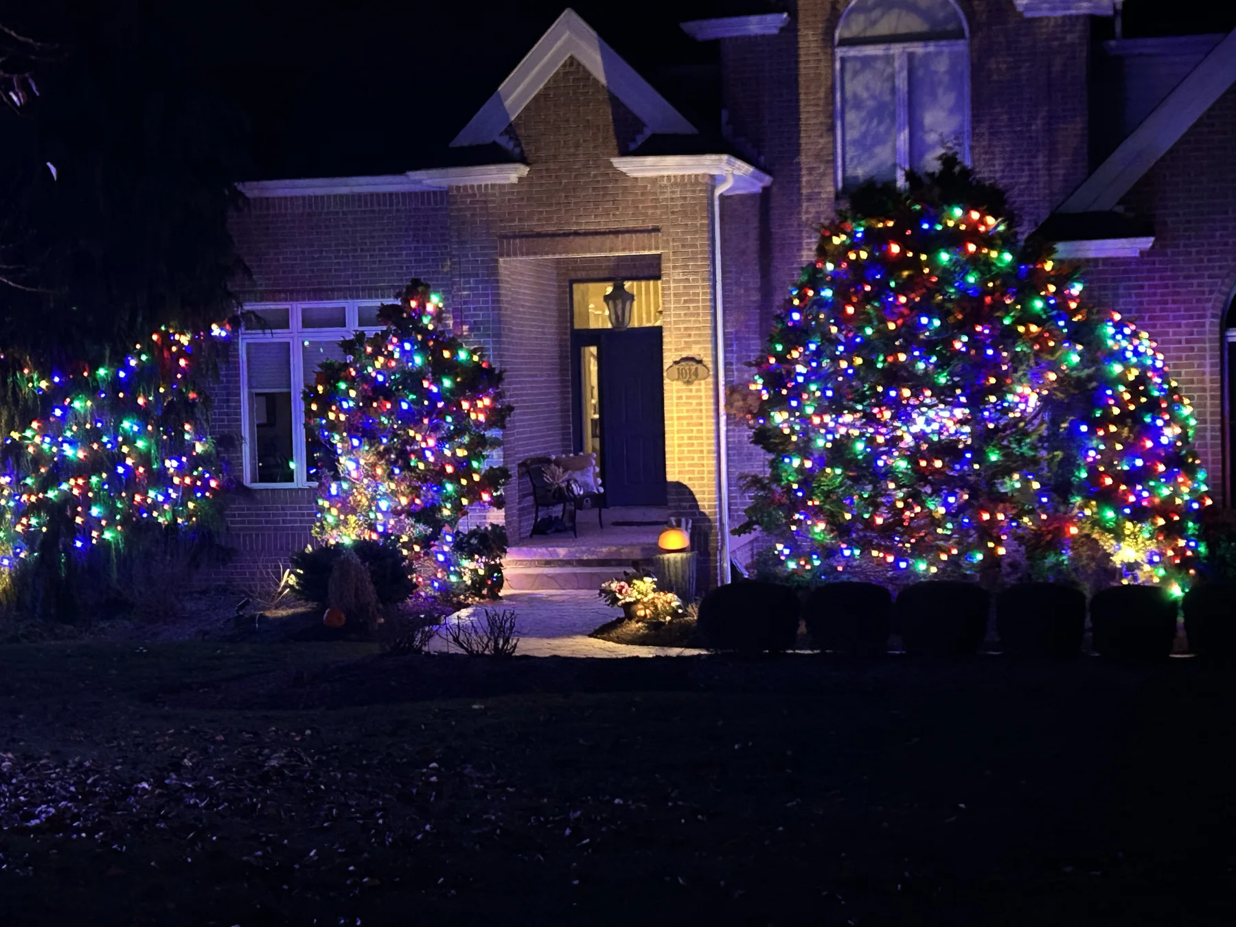 Warm white Christmas lights outlining a large brick home