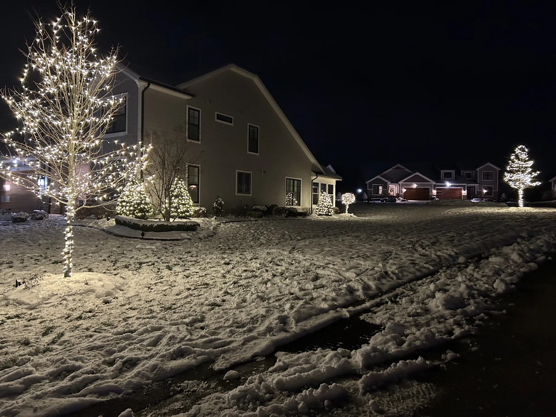 Snowy landscape with warm white Christmas lights in the trees